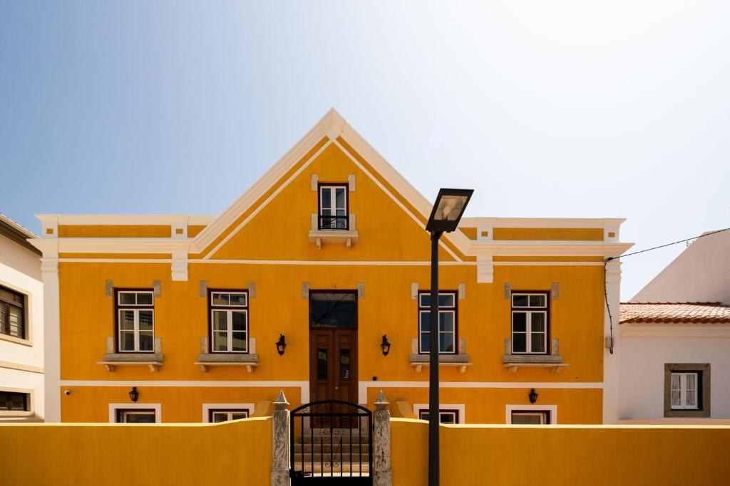 Villa Galega - casa portuguesa de fachada laranja em Santa Cruz